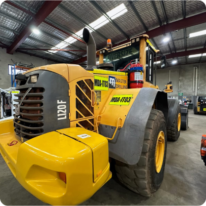 A large yellow truck is parked in a warehouse.